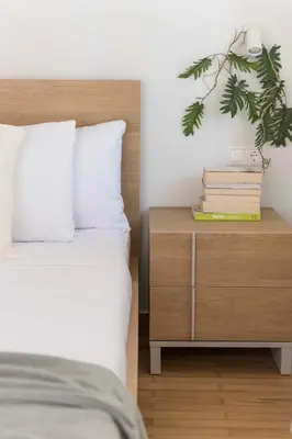 a bedroom with a bed and a nightstand with books at Chic & Spacious 3BR Apartment at National Museum by UPSTREET in Athens