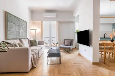 a living room with a couch and a tv at Chic & Spacious 3BR Apartment at National Museum by UPSTREET in Athens