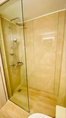 a shower with a glass door in a bathroom at Ilisia mini suite in Athens