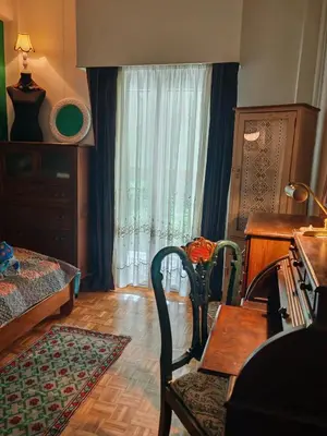 a living room with a table and a chair and a desk at Retro private room in common apartment in Athens