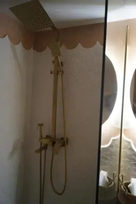 a shower in a bathroom with a mirror at Retro private room in common apartment in Athens