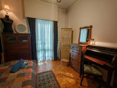 a bedroom with a bed and a dresser and a mirror at Retro private room in common apartment in Athens