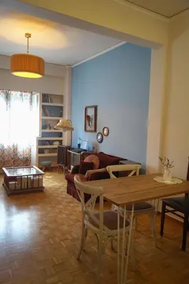 a living room with a table and a couch at Retro private room in common apartment in Athens