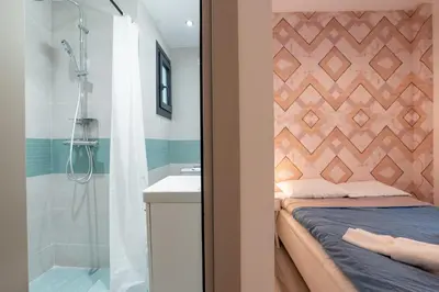 a bedroom with a bed and a shower and a sink at Downtown Penthouse With Gym And Acropolis View in Athens