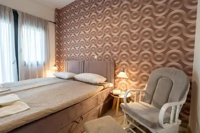 a bedroom with a bed and a chair at Downtown Penthouse With Gym And Acropolis View in Athens