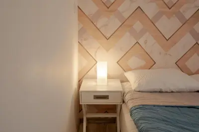 a bedroom with a bed and a nightstand with a lamp at Downtown Penthouse With Gym And Acropolis View in Athens