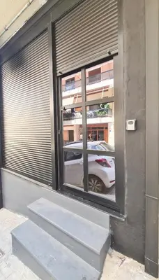 a reflection of a white car in a window at The Black key in Athens