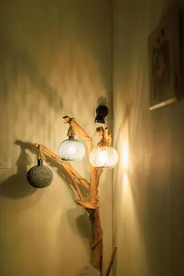 two birds sitting on a branch light on a wall at Aiolos Elegant retro suite in GLYFADA centre in Athens