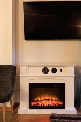 a fireplace with a television on top of it at Aiolos Elegant retro suite in GLYFADA centre in Athens