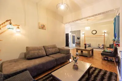 a living room with a couch and a table at Aiolos Elegant retro suite in GLYFADA centre in Athens