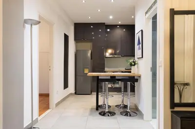 a kitchen with a island in the middle of a room at Aiolos Elegant retro suite in GLYFADA centre in Athens