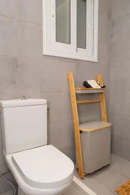 a bathroom with a toilet and a shelf and a mirror at M23 by SpitiSou in Athens