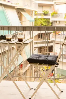 a chair sitting at a table on a balcony at M23 by SpitiSou in Athens