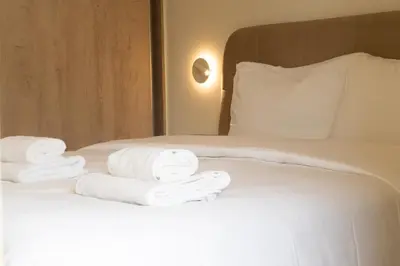 a pile of towels sitting on top of a bed at Palm & Pearl Apartment in Athens