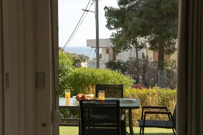 a table and chairs with a view of the ocean at Palm & Pearl Apartment in Athens