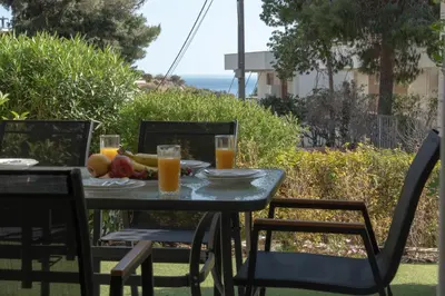 a table with a plate of fruit and glasses of orange juice at Palm & Pearl Apartment in Athens