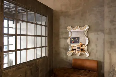 a mirror on a wall in a room with a chair at Alter Athens in Athens