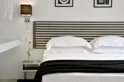 a white bed with a black and white headboard at Alter Athens in Athens