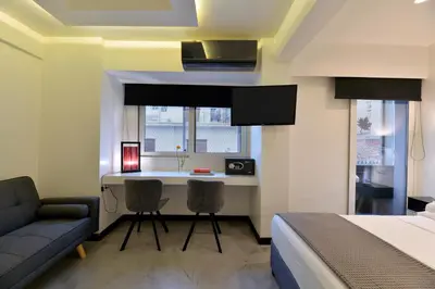 a bedroom with a bed and a desk with two chairs at Alter Athens in Athens