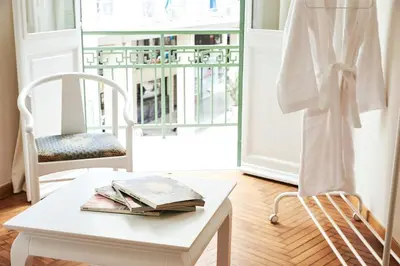 a white chair and a table with a book on it at Perikleous Apartment in Athens