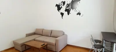 a living room with a couch and a world map on the wall at Dafni's Super Home in Athens