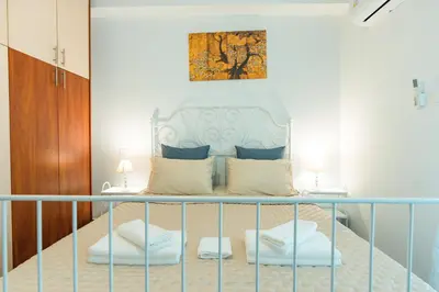 a bedroom with a bed with two night stands and two lamps at Ma de Bright Stay Attiki Metro in Athens
