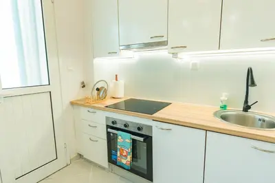 a kitchen with white cabinets and a sink and a stove at Ma de Bright Stay Attiki Metro in Athens