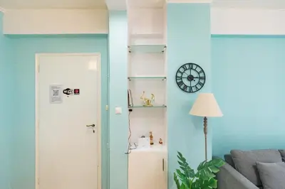 a room with a couch and a clock on the wall at Ma de Bright Stay Attiki Metro in Athens