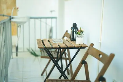 a small table on a balcony with two chairs at Ma de Bright Stay Attiki Metro in Athens