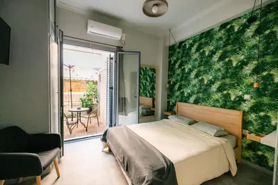 a bedroom with a bed with a green wall at The Athens Green Apt in Athens