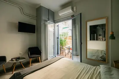 a bedroom with a bed and a view of a patio at The Athens Green Apt in Athens