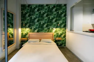 a bedroom with a bed with a green wall at The Athens Green Apt in Athens