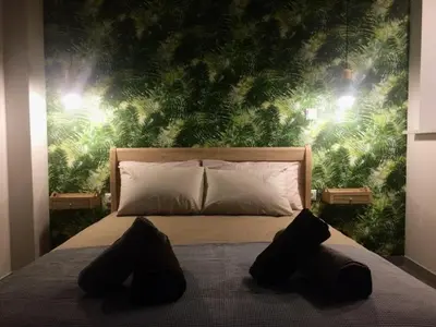 a bedroom with a bed with a green wall at The Athens Green Apt in Athens