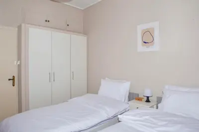 two beds in a room with white walls and white pillows at P23 by SpitiSou in Athens