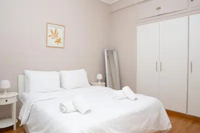 a white bedroom with a large bed with white sheets at P23 by SpitiSou in Athens
