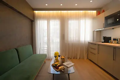 a living room with a green couch and a table at Psiri 38 Boutique Balcony Suite in Athens