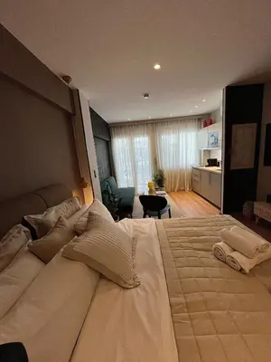 a bedroom with a large bed and a living room at Psiri 38 Boutique Balcony Suite in Athens
