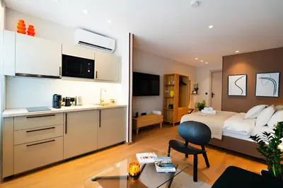 a bedroom with a king sized bed and a kitchen at Psiri 38 Boutique Balcony Suite in Athens
