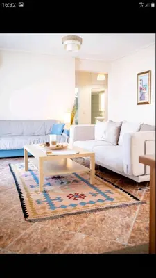 a living room with a white couch and a coffee table at Beautiful Victoria in Athens
