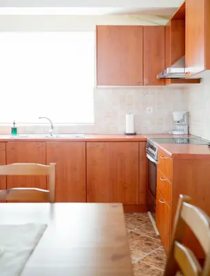 a kitchen with wooden cabinets and a stove top oven at Beautiful Victoria in Athens