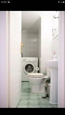 a white bathroom with a toilet and a sink at Beautiful Victoria in Athens