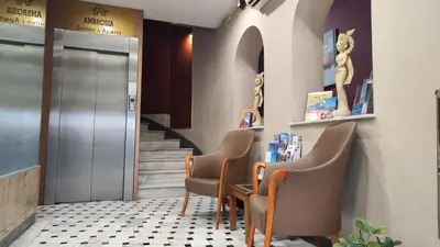 a waiting room with three chairs and a table and stairs at Ambrosia Suites in Athens