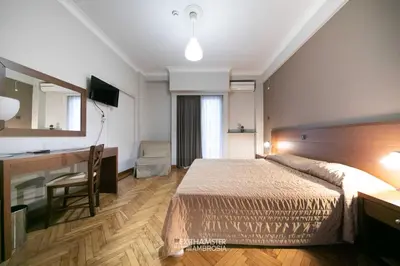 a bedroom with a bed and a desk and a mirror at Ambrosia Suites in Athens