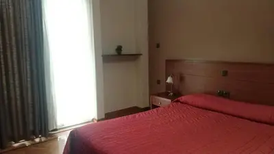 a bedroom with a red bed with a large window at Ambrosia Suites in Athens