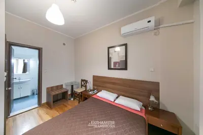 a bedroom with a bed and a desk and a window at Ambrosia Suites in Athens