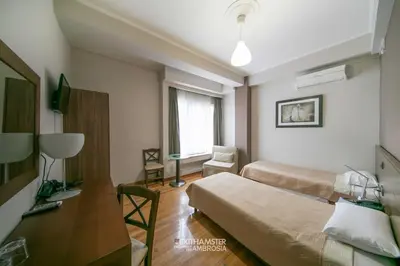 a hotel room with two beds and a desk at Ambrosia Suites in Athens