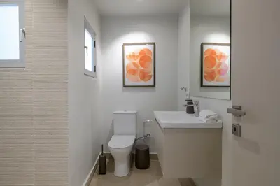 a white bathroom with a toilet and a sink at Acropolis Dream with Plunge Pool in Athens