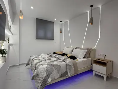 a bedroom with a bed with a tv on the wall at Stylish Athens Base near Acropolis & Metro in Athens