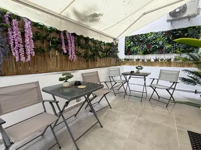 a patio with two tables and chairs and flowers at Stylish Athens Base near Acropolis & Metro in Athens