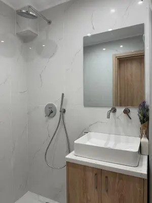 a white bathroom with a sink and a shower at Stylish Athens Base near Acropolis & Metro in Athens